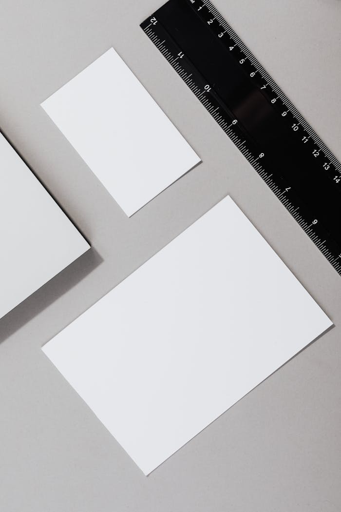 about-01 Flat lay of blank paper sheets and ruler on a gray background, ideal for office themes.