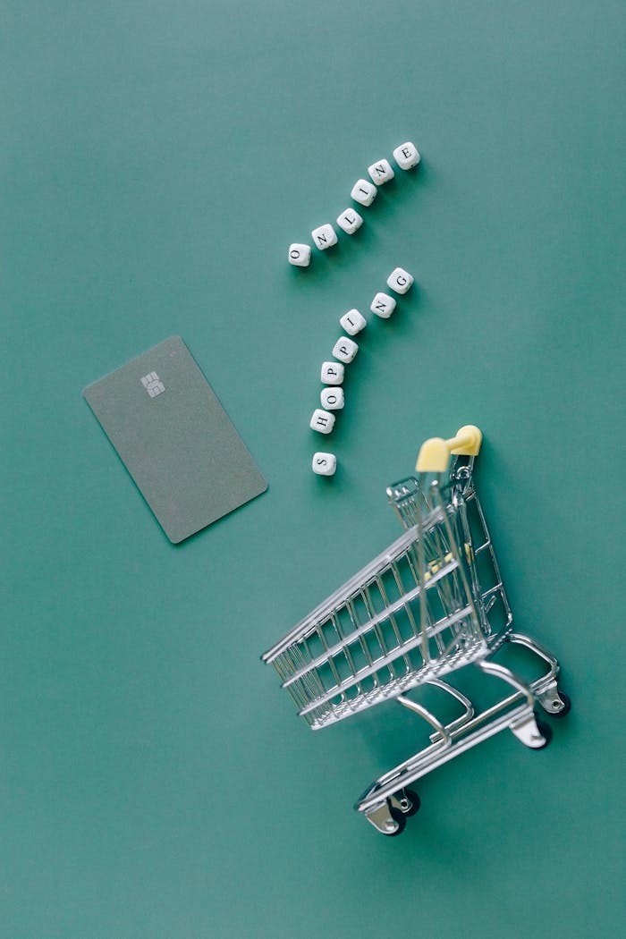 services-02 A conceptual image featuring a mini shopping cart, credit card, and letter blocks spelling 'online shopping' on a green background.